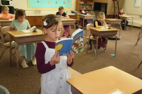 Student reading book in class room