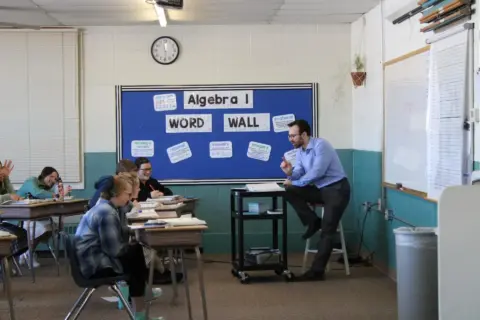 Teacher instructing students in Algebra